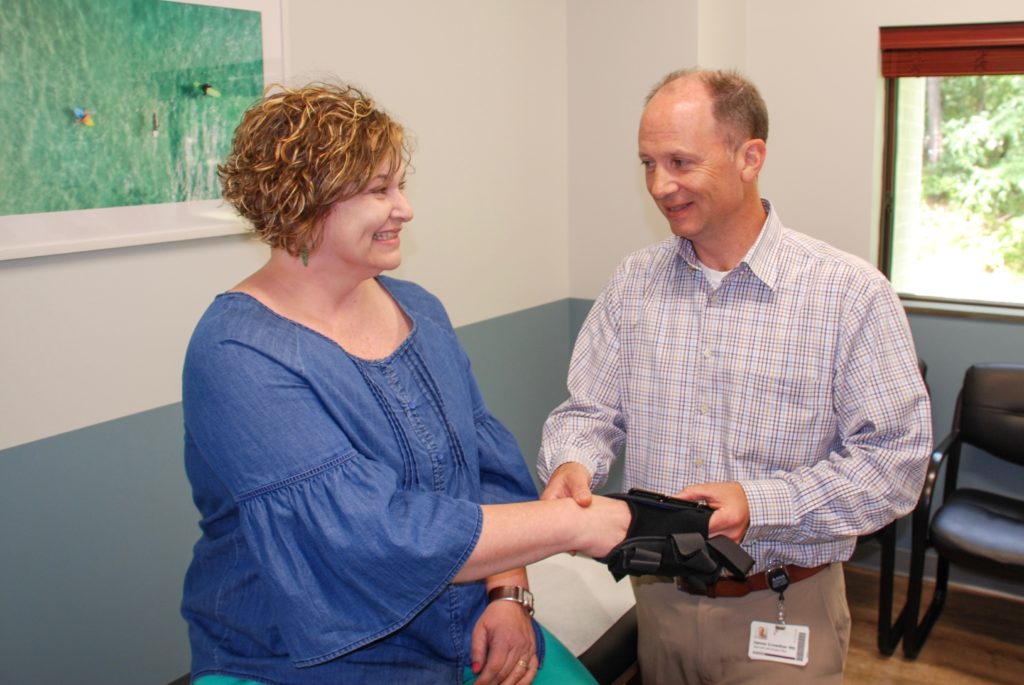 Dr. Crowther removing a brace from a patient's wrist. 