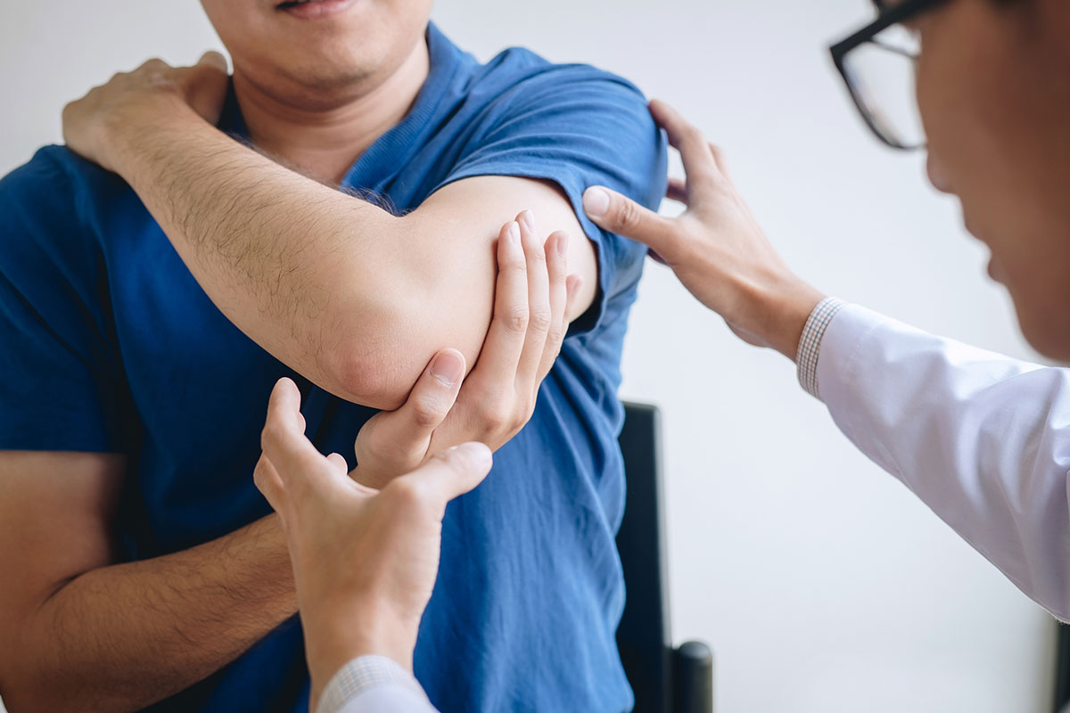 Doctor physiotherapist assisting a male patient while giving exercising treatment.