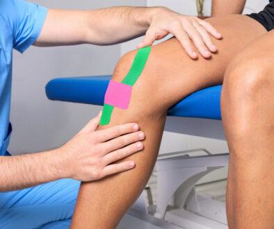 A therapist uses specialized tape on a patient in orthopedic physical therapy