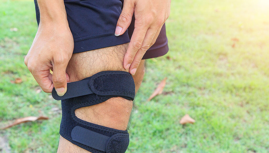 Closeup of a Man Putting on a Patella Tendon Strap Non-surgical Patellar tendinitis Treatment