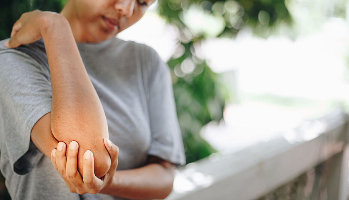 Closeup Of A Woman Holding Her Elbow Experiencing Elbow Pain When Bending