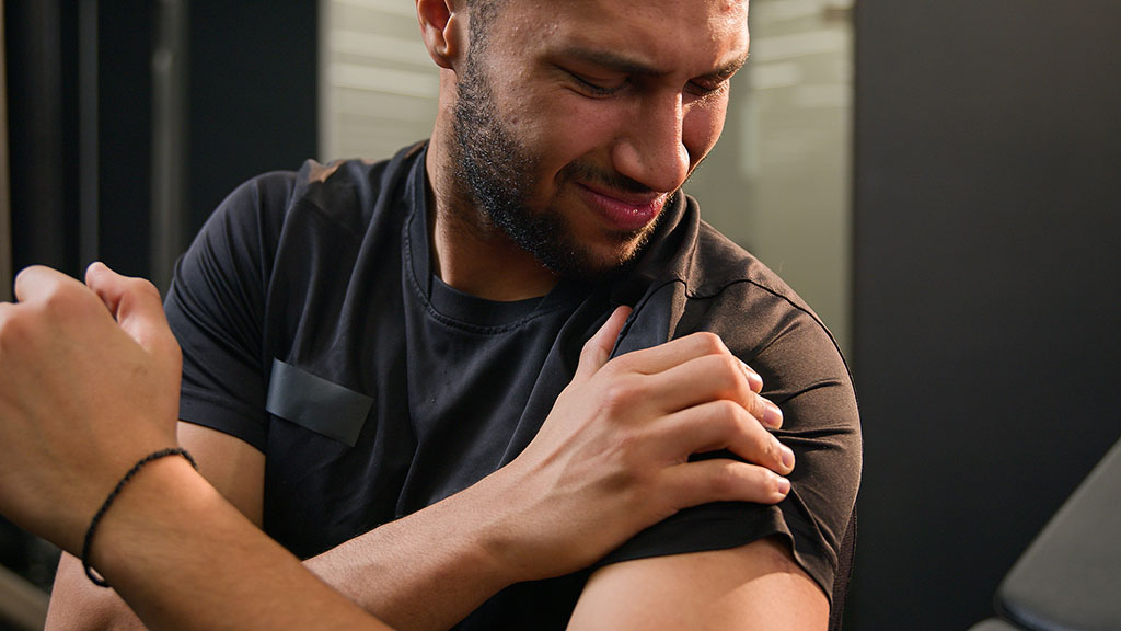 Closeup Of An African American Man Holding His Shoulder In Pain What Causes A Separated Shoulder