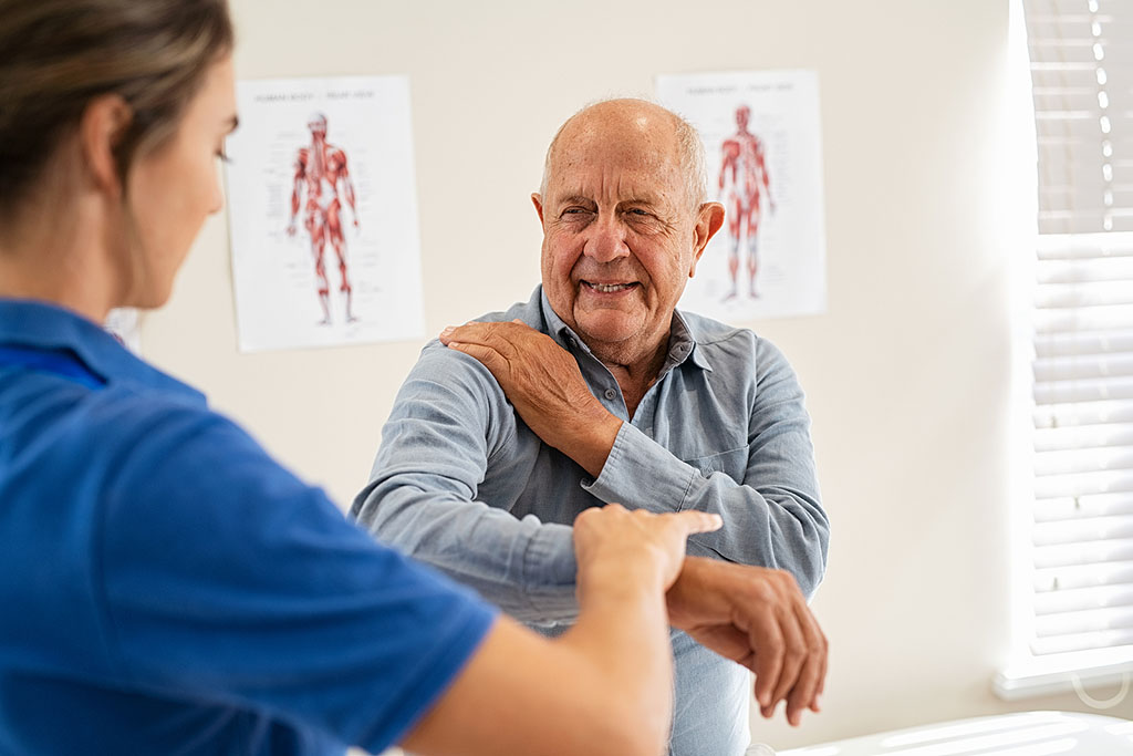 A Physical Therapist Assisting A Senior Man With A Shoulder Movement During Labrum Tear Recovery